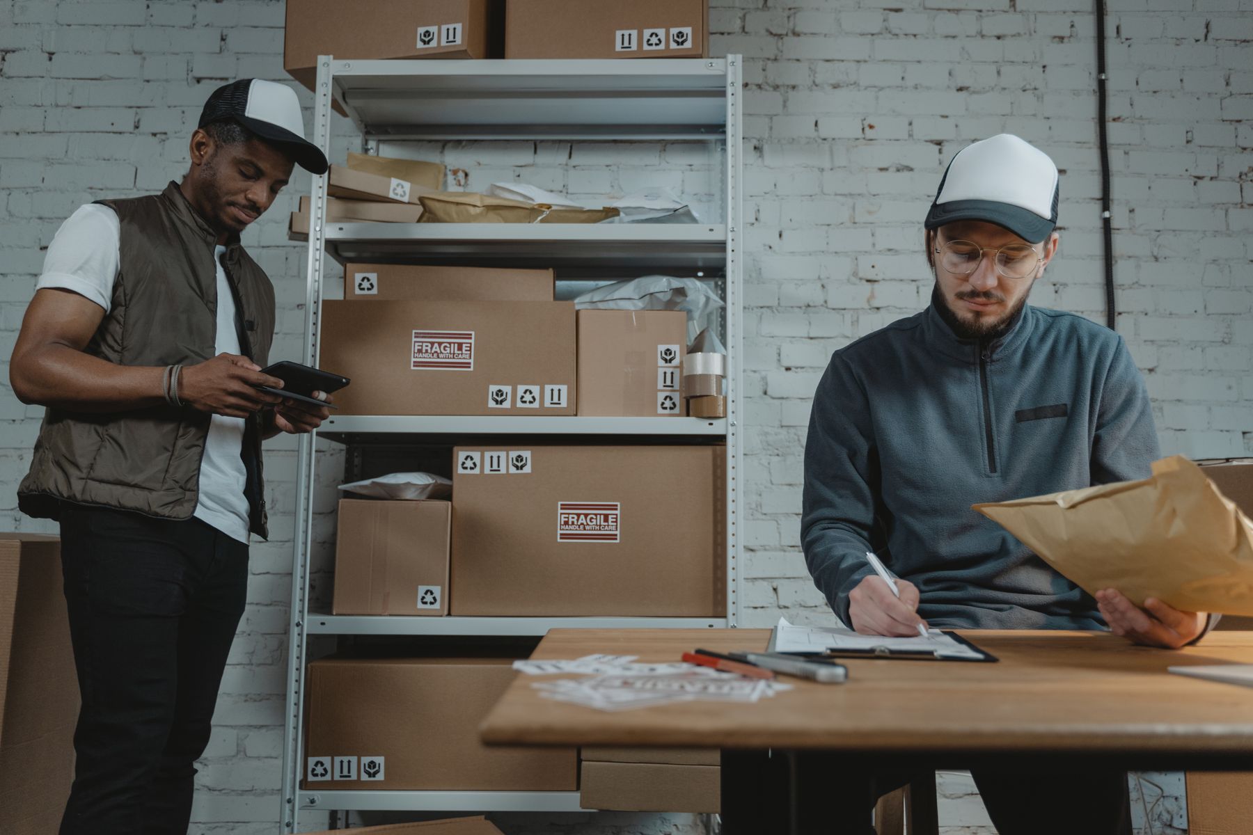 Two courier team members processing unbranded parcels in a warehouse